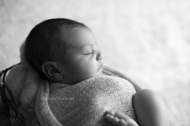 bébé emmailloté dans panier